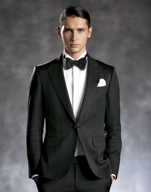 A pointed peak lapel black tuxedo, with a tuxedo shirt and a black bow tie, a perfect combination for all formal occasions
